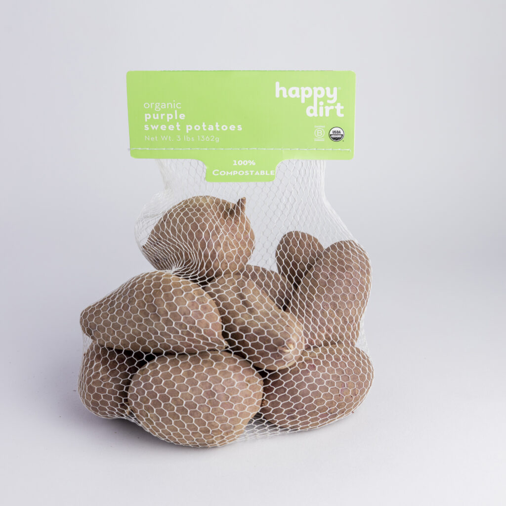 bagged purple organic sweet potatoes on a white backdrop